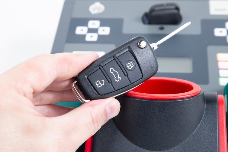 Smart key programming Pleasantville NY close up a hand holding a key fob pointing to the left