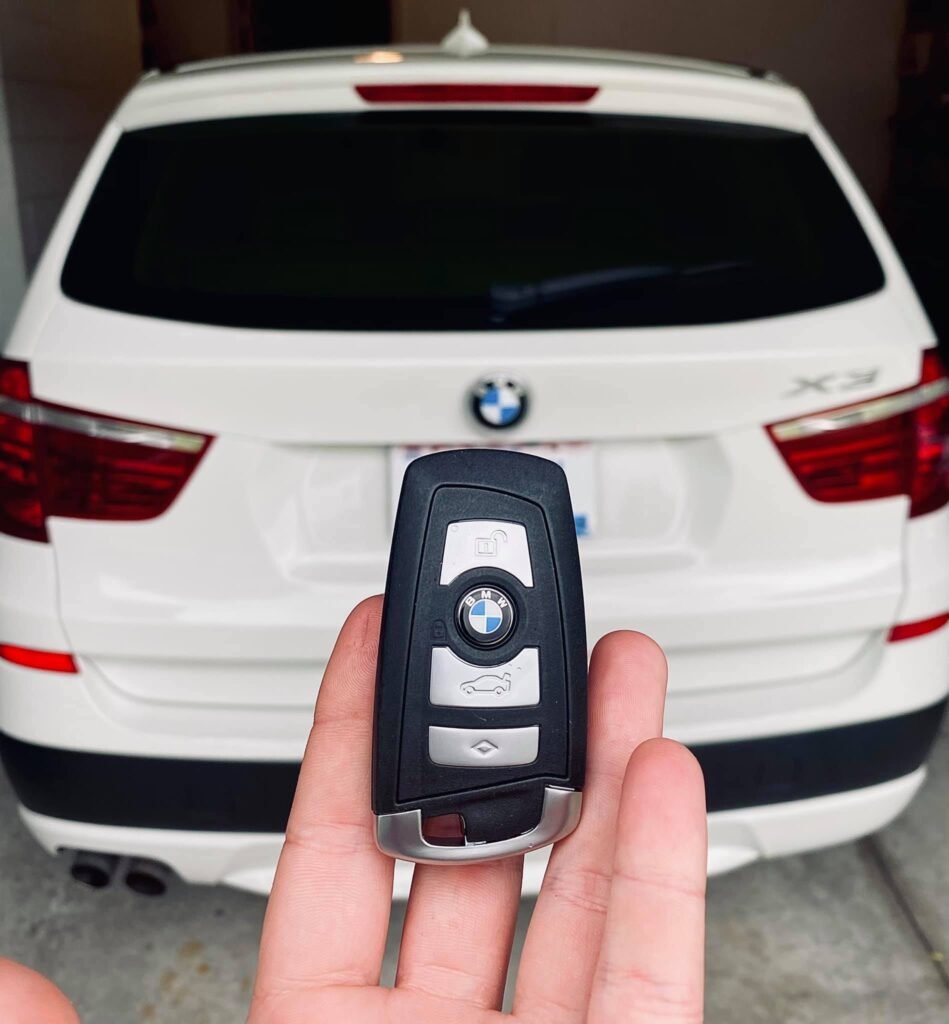 hand holding a key of white bmw