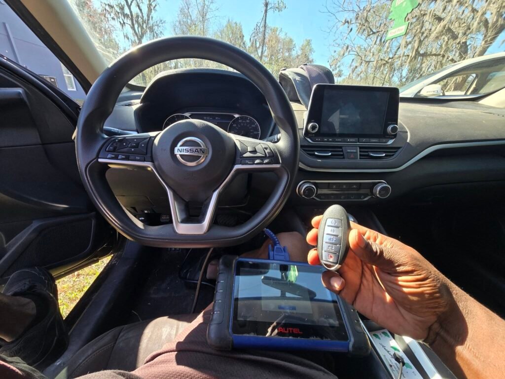 hand holding a nissan smart key and programming it