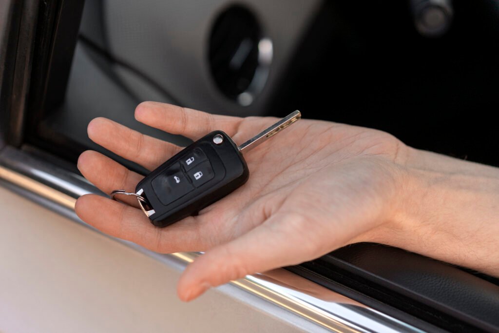 hand of a person inside the car holding a car key