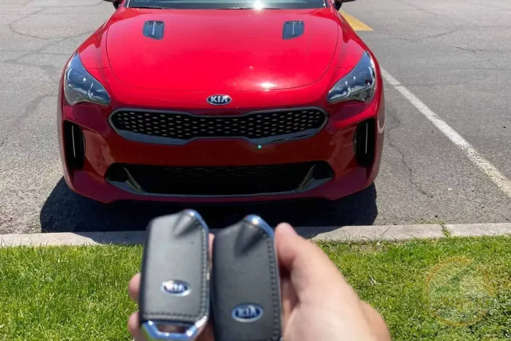 holding a kia key in front of the car