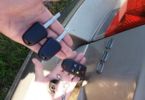 Is It Cheaper to Go to a Locksmith or Dealer Today two hand holding a car key