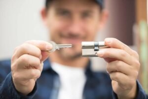 a man holding a key and a door lock