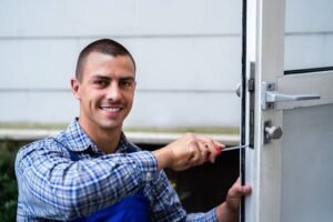 smiling young man repairing the door knob